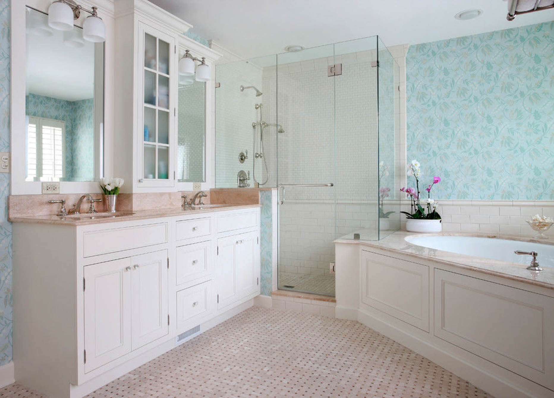 cleanly remodeled bathroom with glass shower door, soaking, tub and custom shelving. The cabinets and walls are light colors.