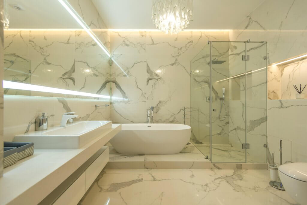Luxurious bathroom with chandelier, vanity lighting and recessed lighting