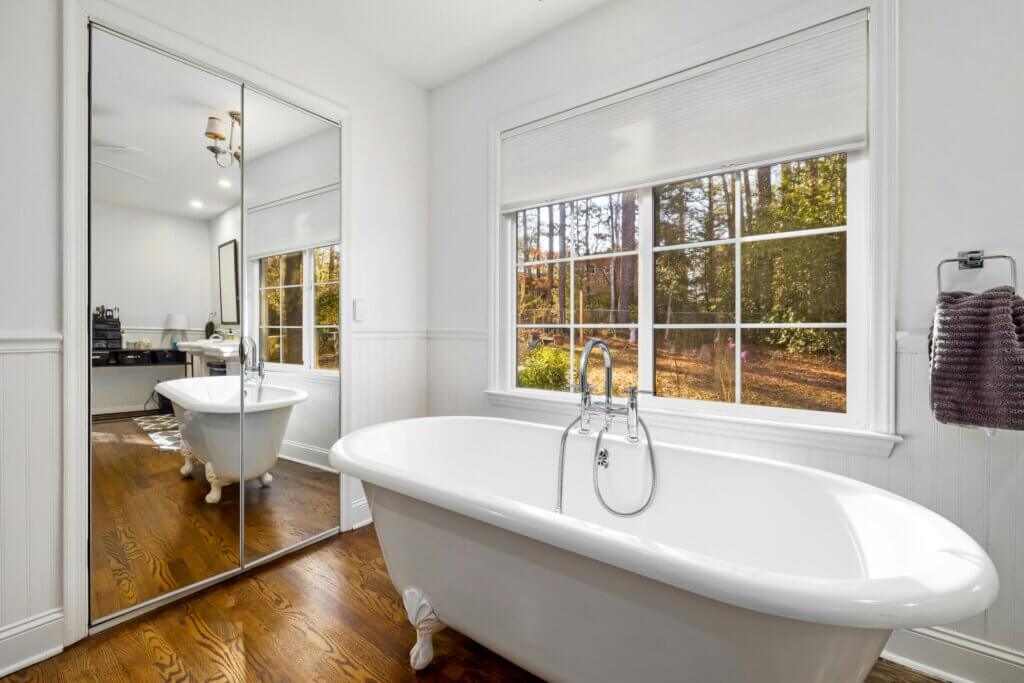 Teak bathroom hardwood flooring and ceramic bath tub