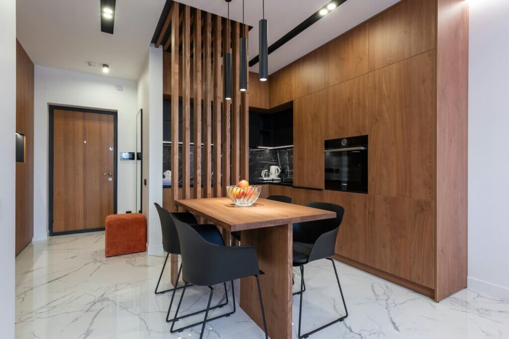 Modern kitchen with wooden cabinets, built-in appliances, and porcelain tile flooring