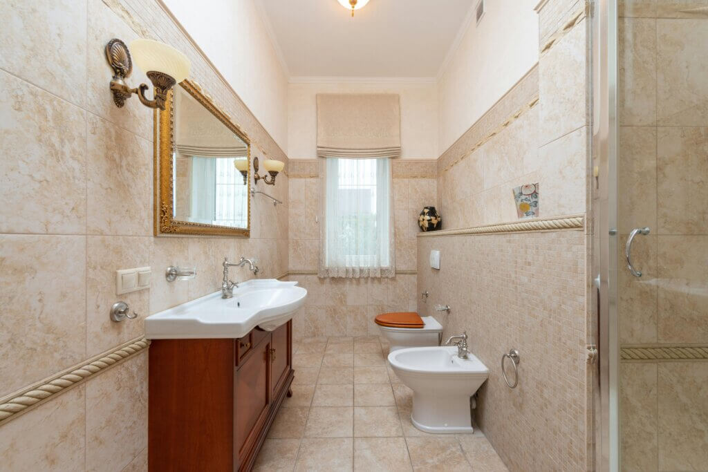 vintage bathroom with ornate mirror and recessed sink