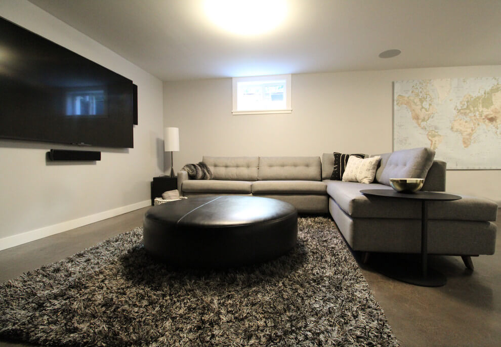 Basement entertainment room with concrete flooring