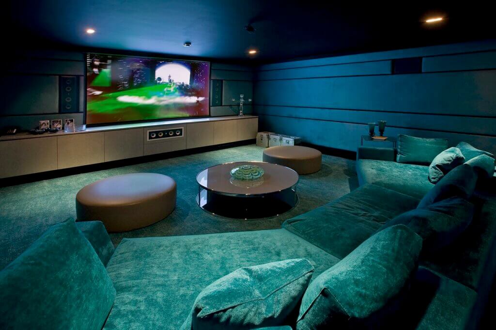 Modern basement with teal walls and carpet flooring