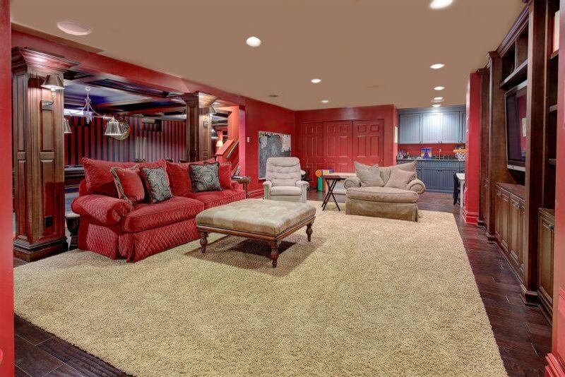 Traditional farmhouse basement in red color scheme with soft textiles and wooden accents